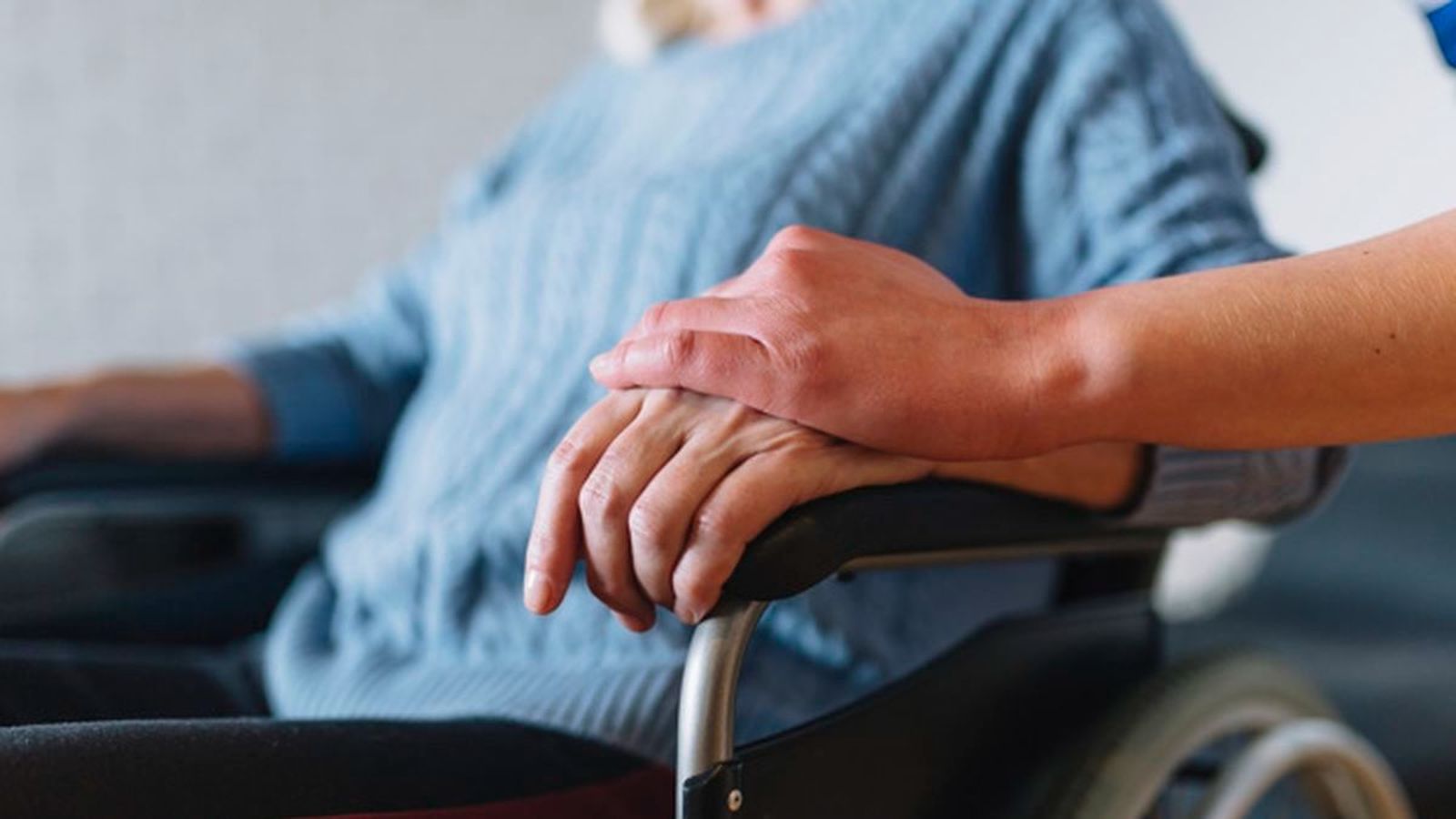 Imagen de archivo de una mujer dependiente que recibe un gesto cariñoso de su cuidadora.