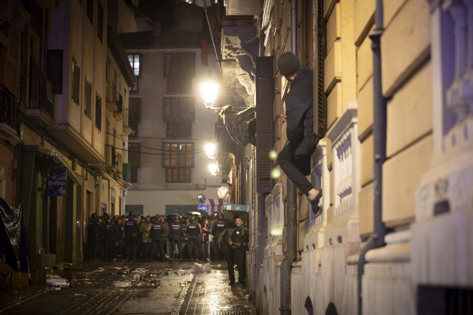 Todas las imágenes: una okupa trepa con cuerda para acceder al piso ocupado en Granada