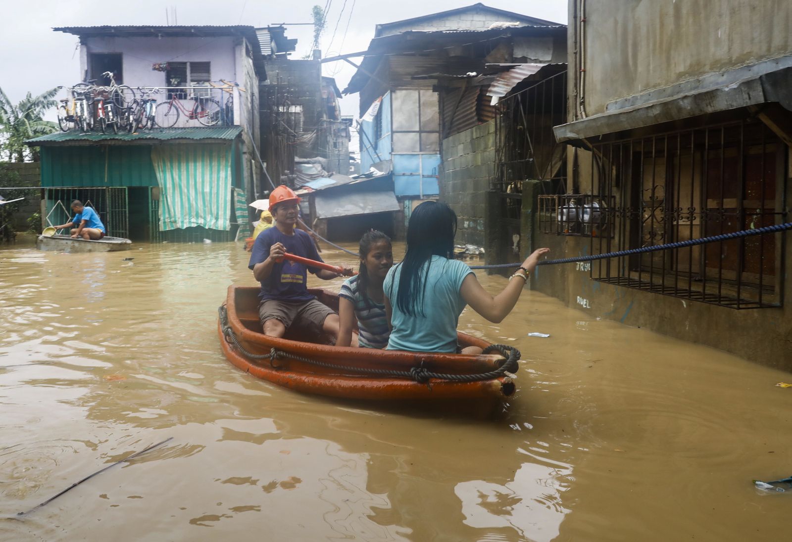 Vecinos de la localidad filipina de San Mateo abandonan ayer en barca sus domicilios inundados por el agua.
