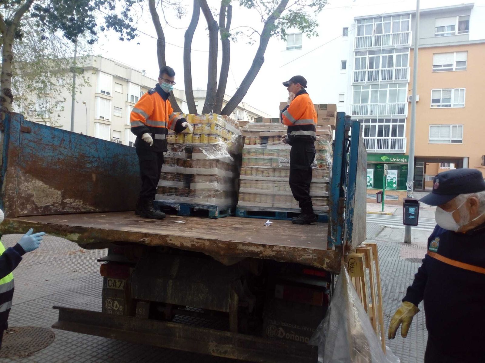 Miembros de Protección Civil descarga el camión del Banco de Alimentos de Cádiz