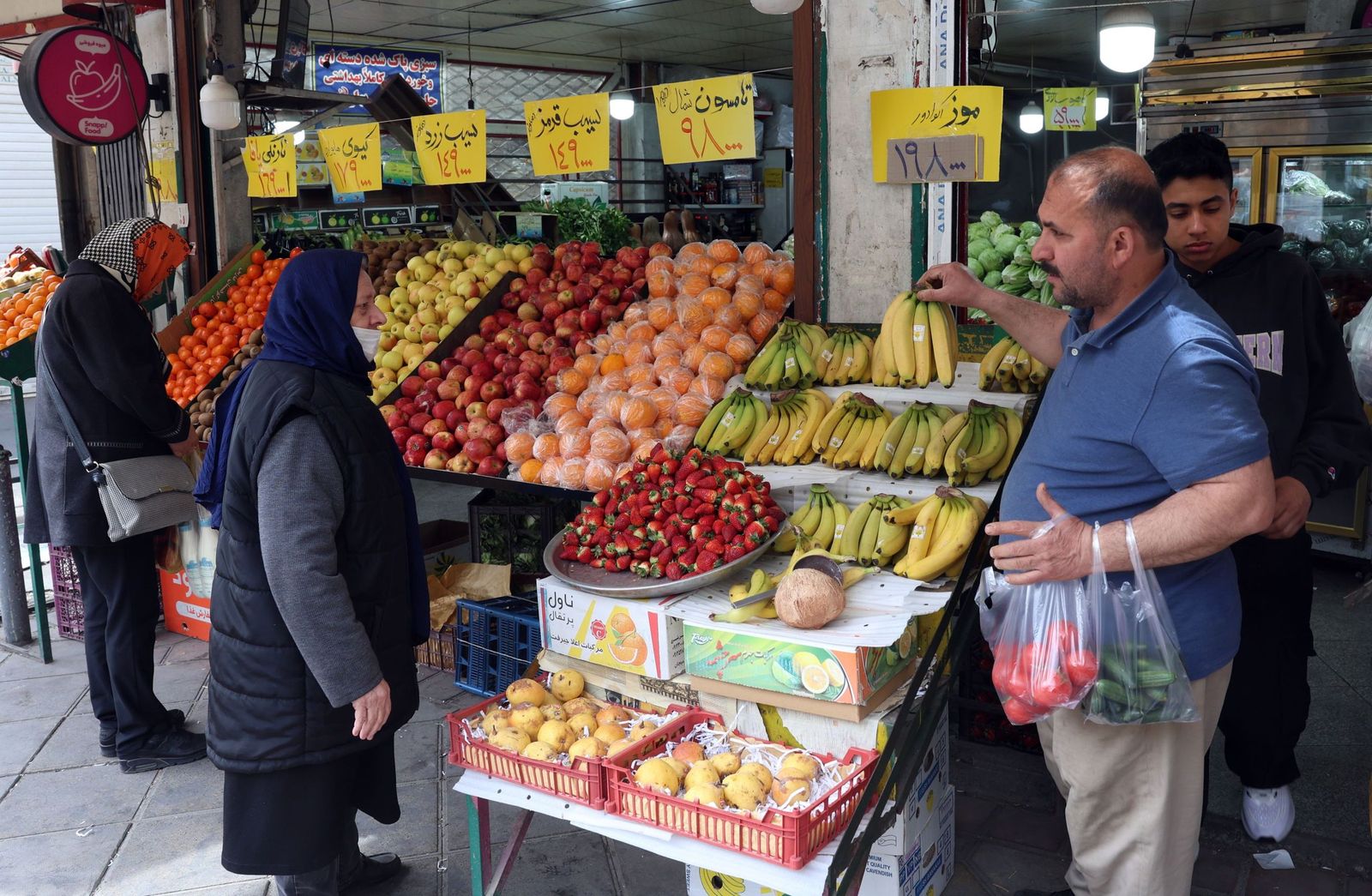 La vida sigue entre los habitantes de Teherán: compras, trabajos, pasear al perro...