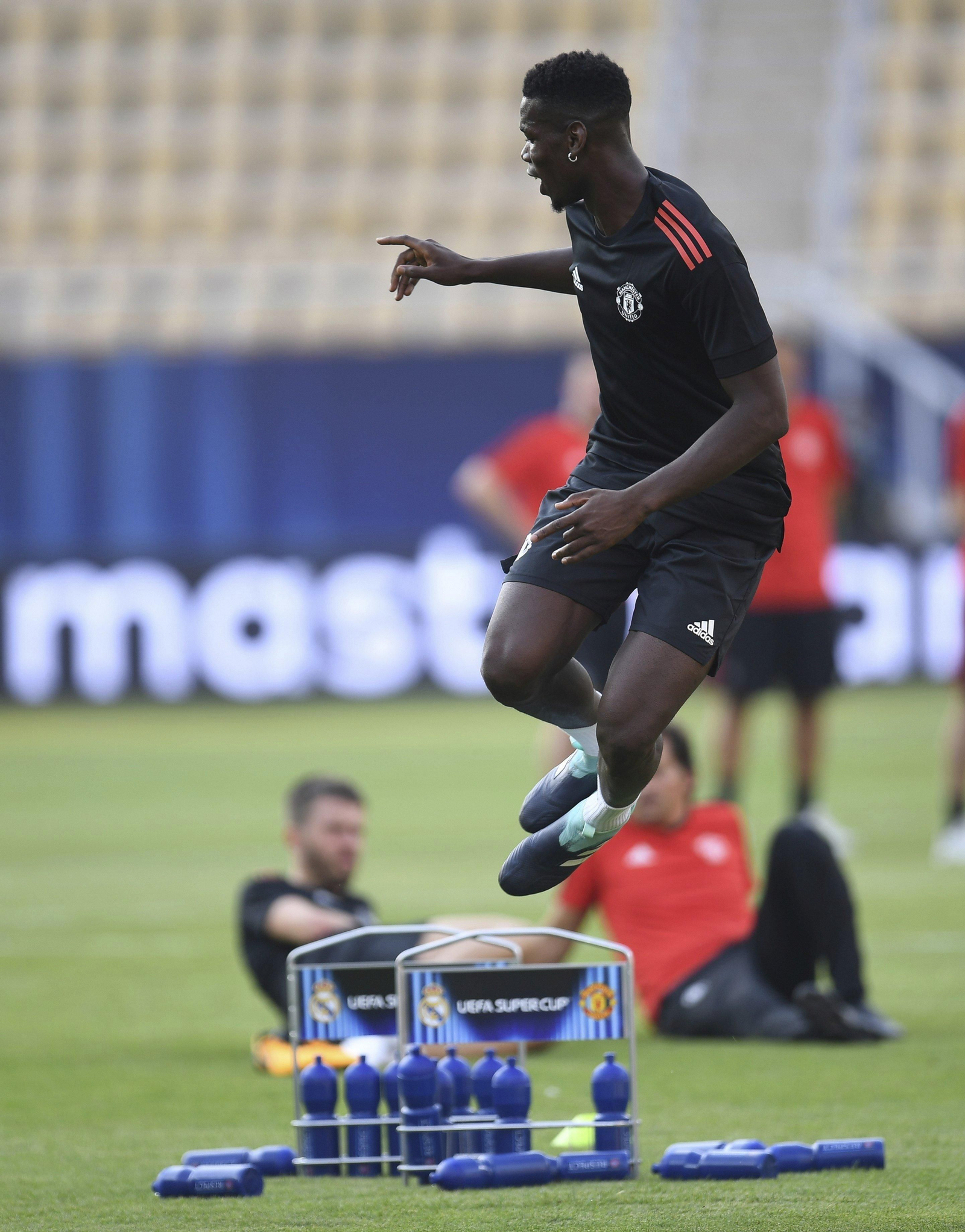 Pogba salta en un entrenamiento con Carrick al fondo.