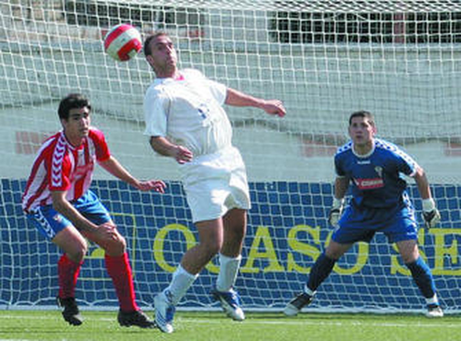 El delantero palmerino Carlos Torres tratando de cabecear al fondo del marco algecireño el balón.