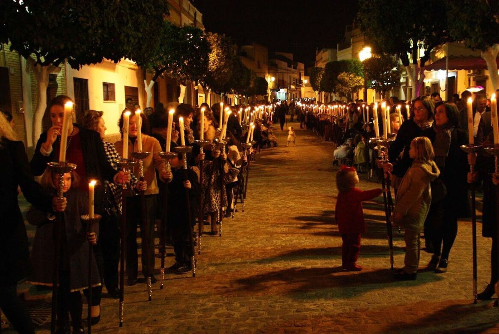 Una larga fila de mujeres soleanas, con hachetas, precede el paso de la Virgen de los Dolores, de Alcalá del Río.
