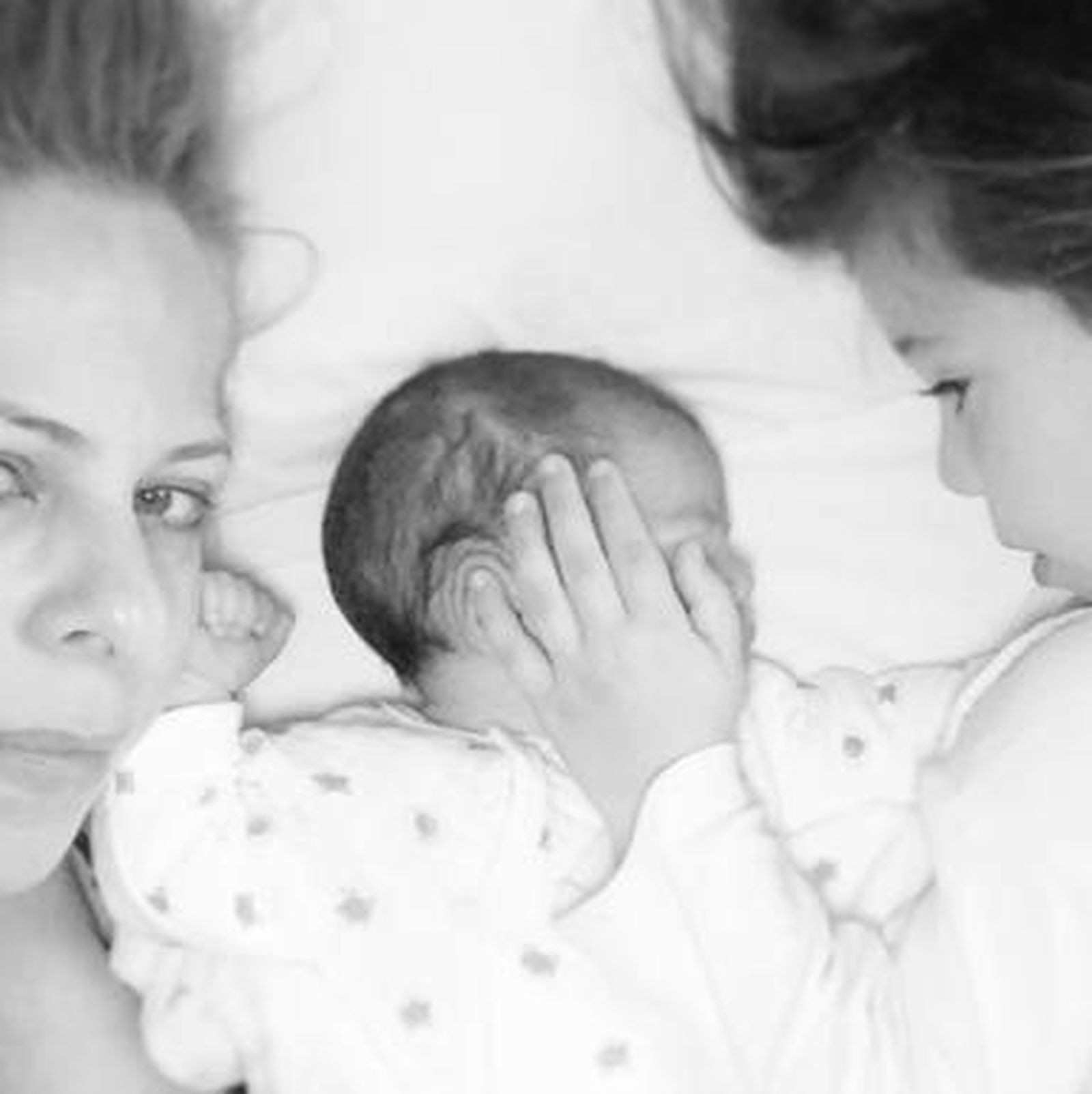 Pastora con sus dos hijas: Vega, con quince días, y Estrella, de cuatro años, acariciando su carita.