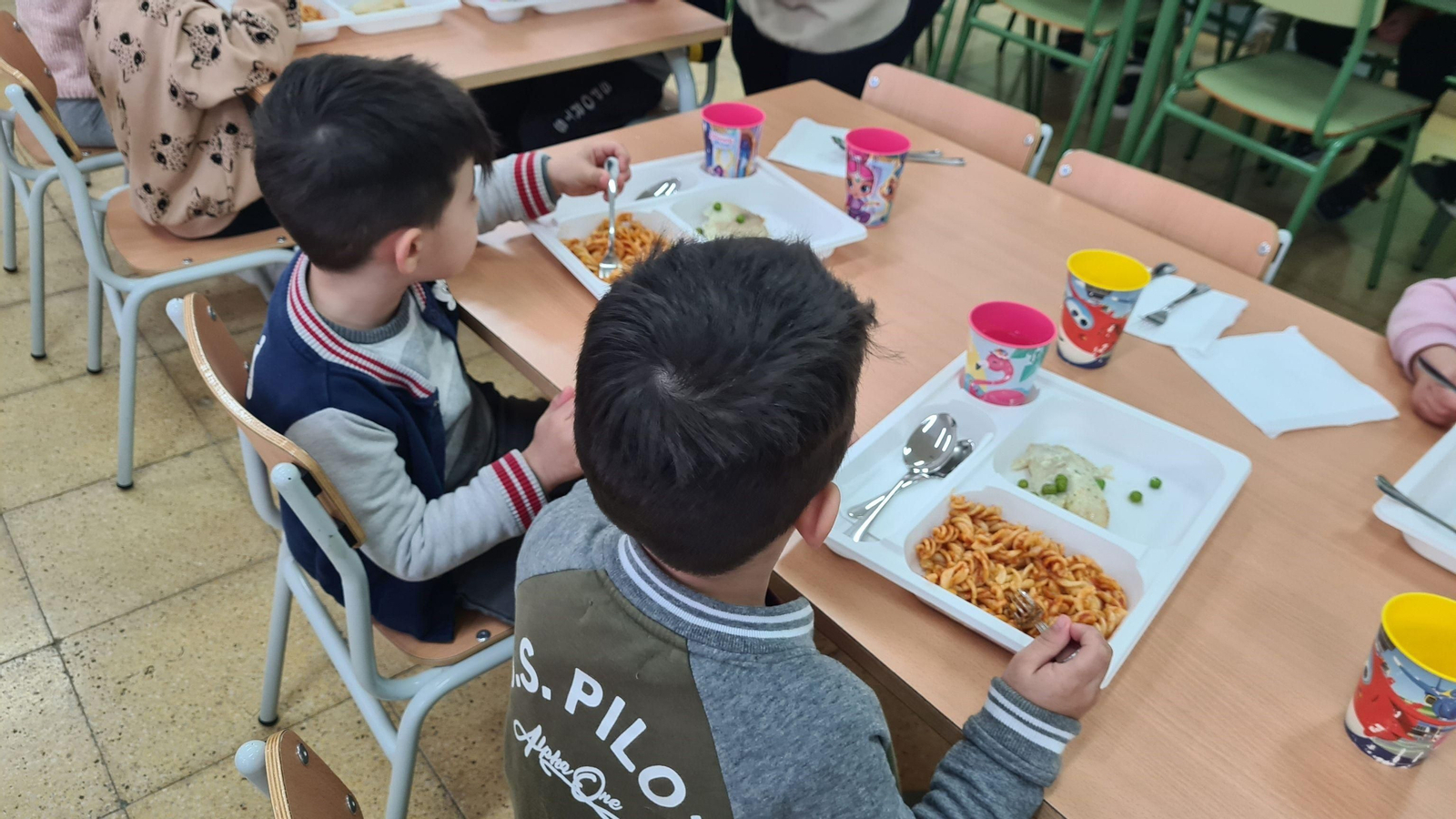 Varios niños en el servicio de comedor escolar.