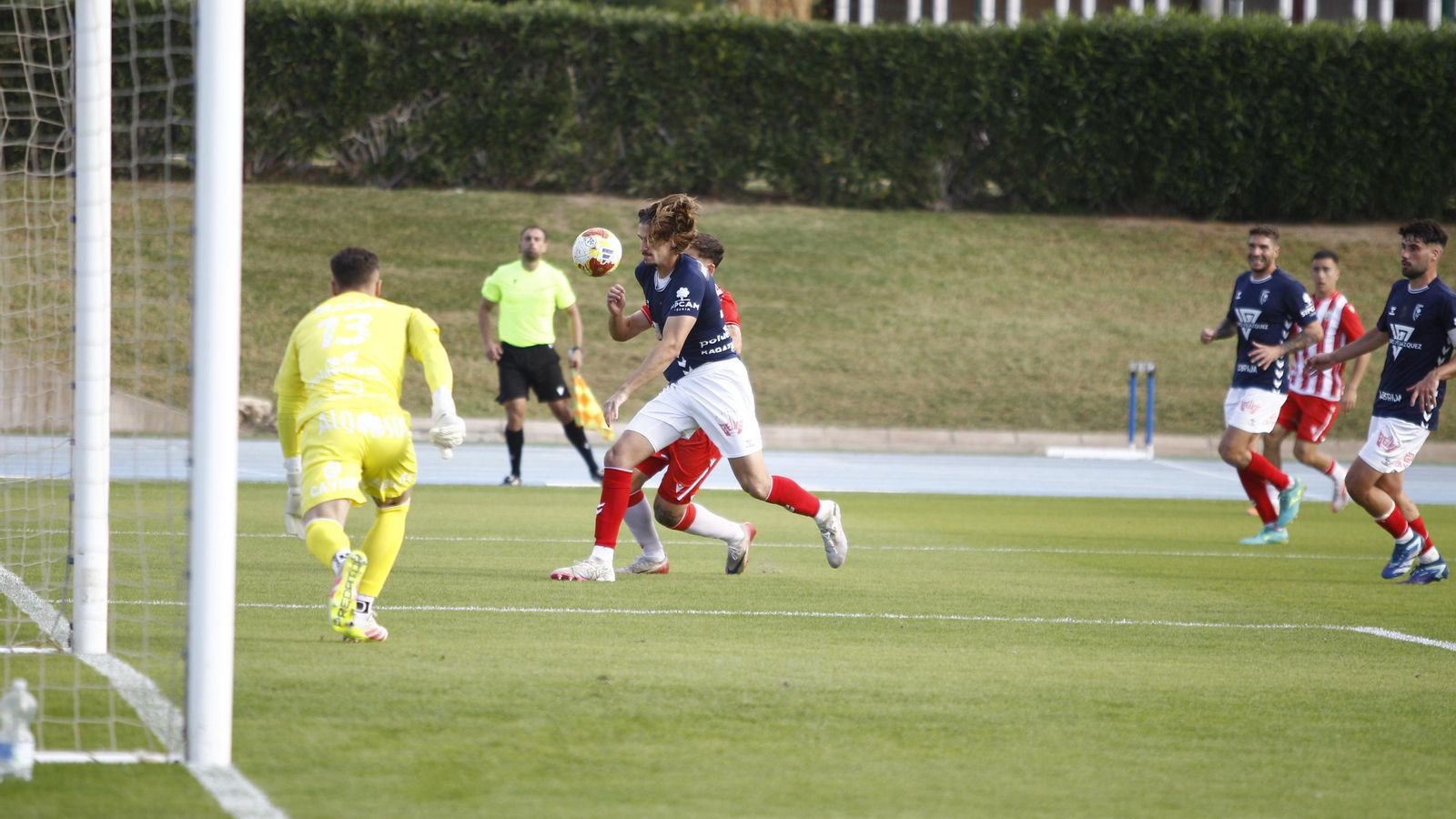 Un defensor protege el balón ante la presión del rojiblanco Iker Burgos durante una acción del encuentro.