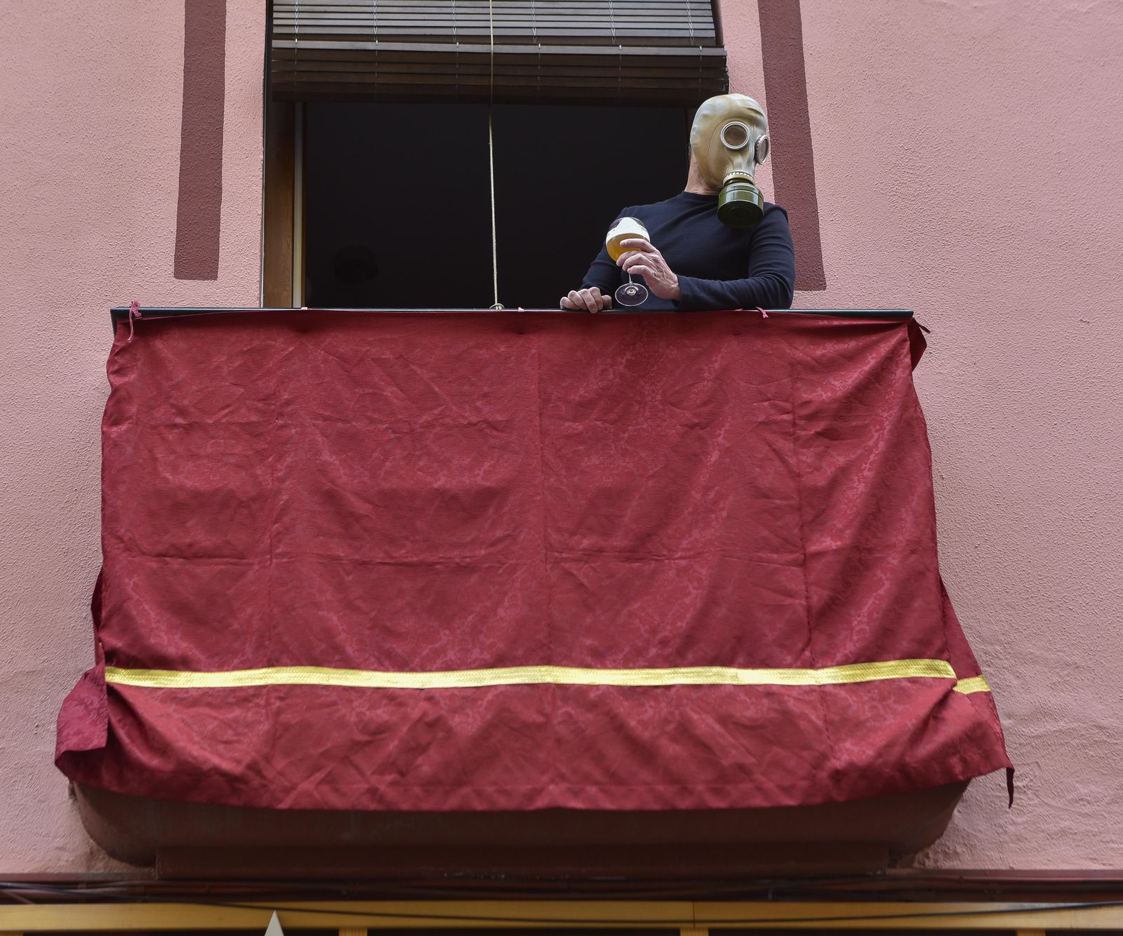 Un hombre con una mascara antigás, como las usadas en la Primera Guerra Mundial, en un balcón