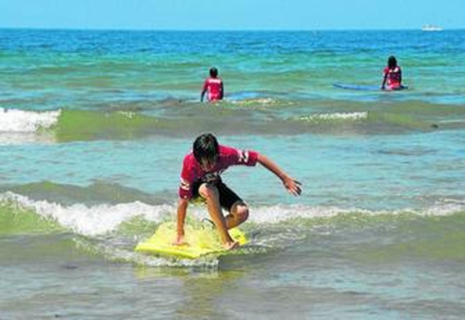 Alumnos de una de las escuelas de surf de la ciudad ayer en la playa de Cortadura.