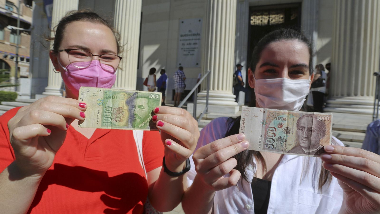 Dos mujeres sostienen un billete de 1.000 y 5.000 pesetas