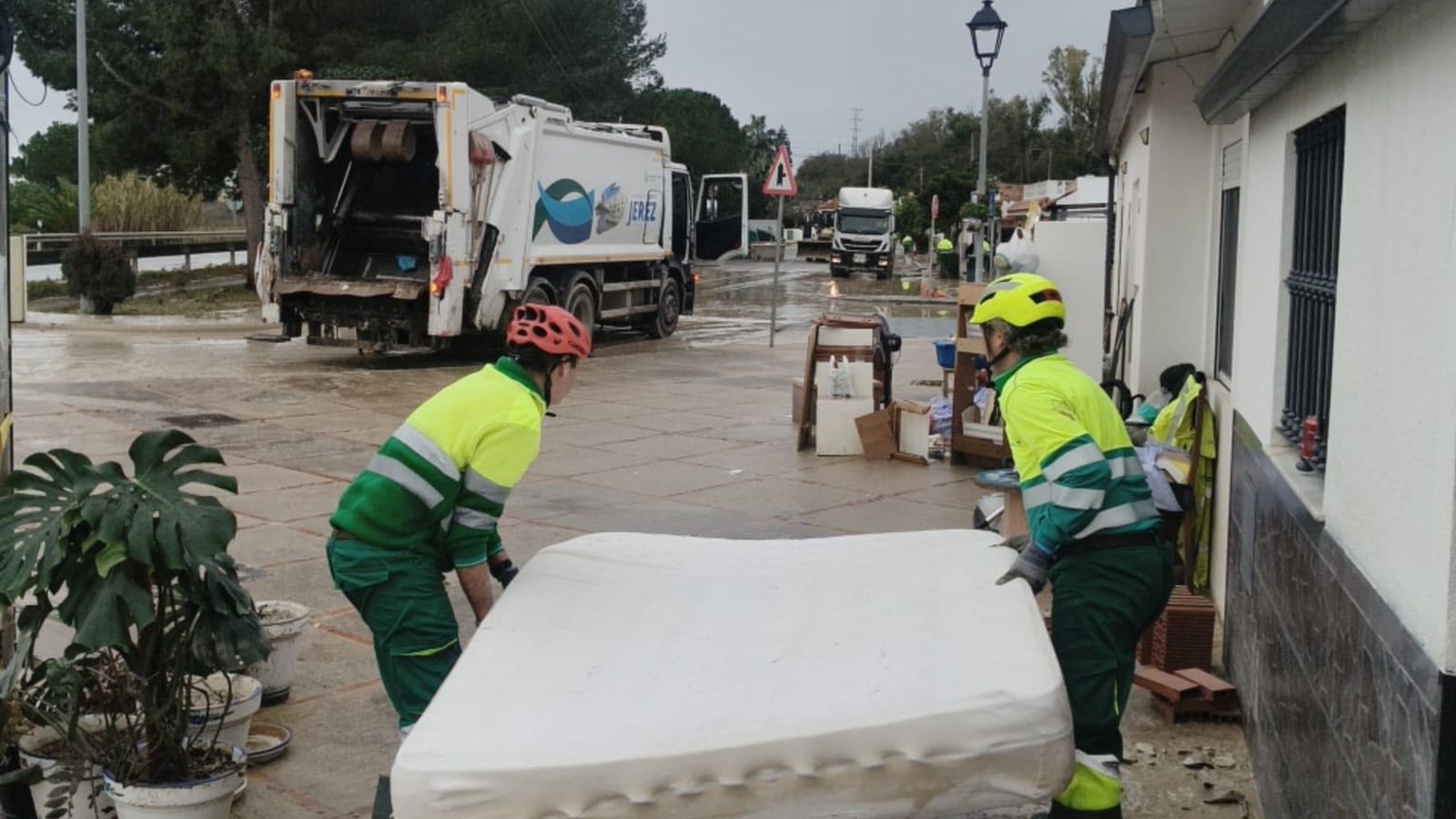 Trabajadores municipales ayudan en la retirada de enseres en las zonas de Jerez afectadas por inundaciones.