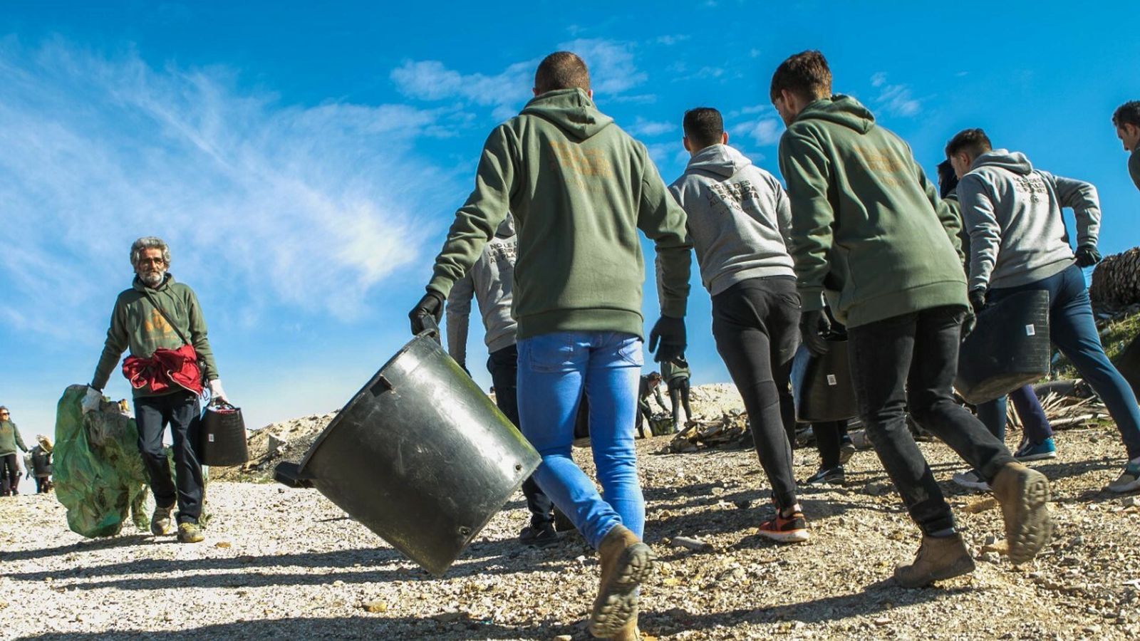 Voluntarios con cubas y basura.