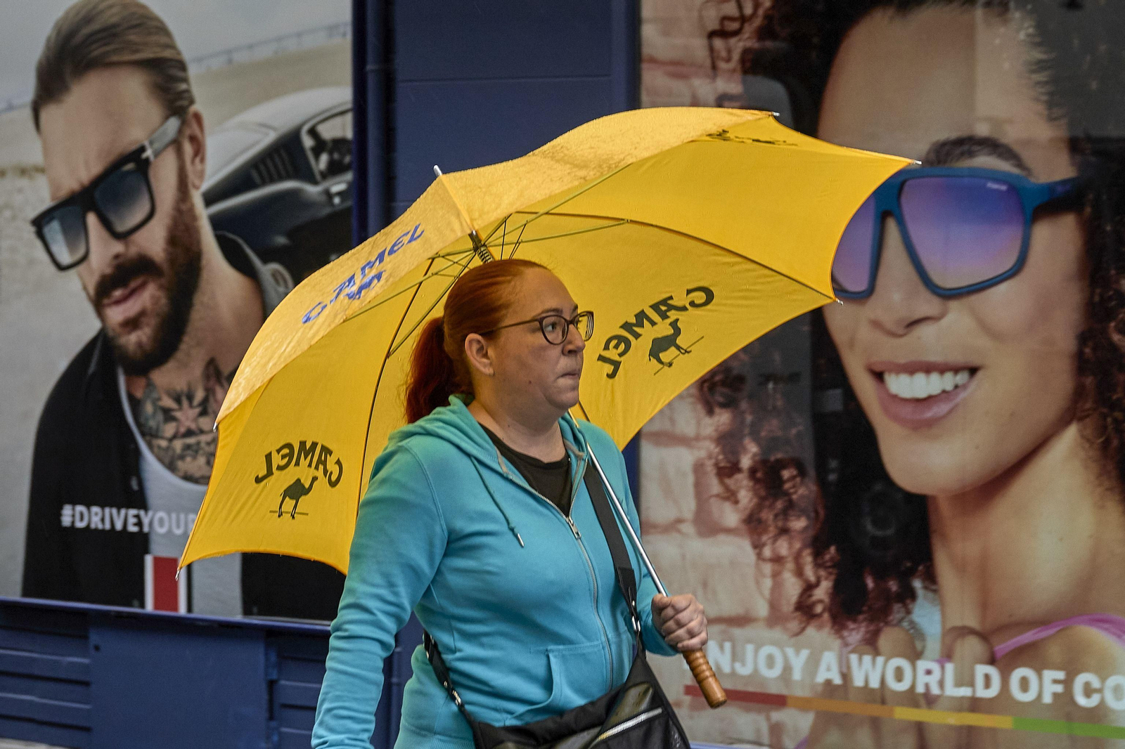 Una mujer se protege con un paraguas de la lluvia.