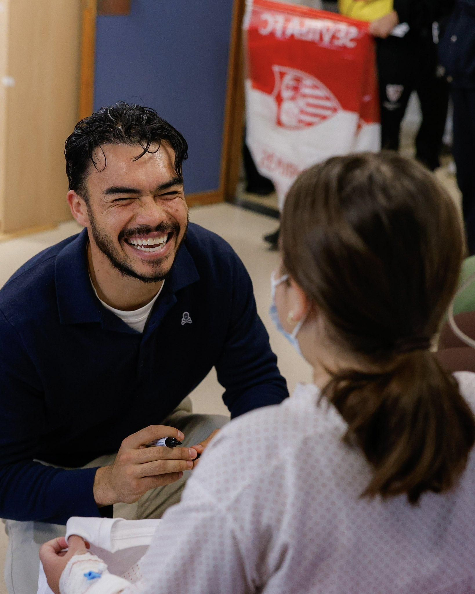 Suazo le firma muy sonriente una camiseta del Sevilla a una niña ingresada.