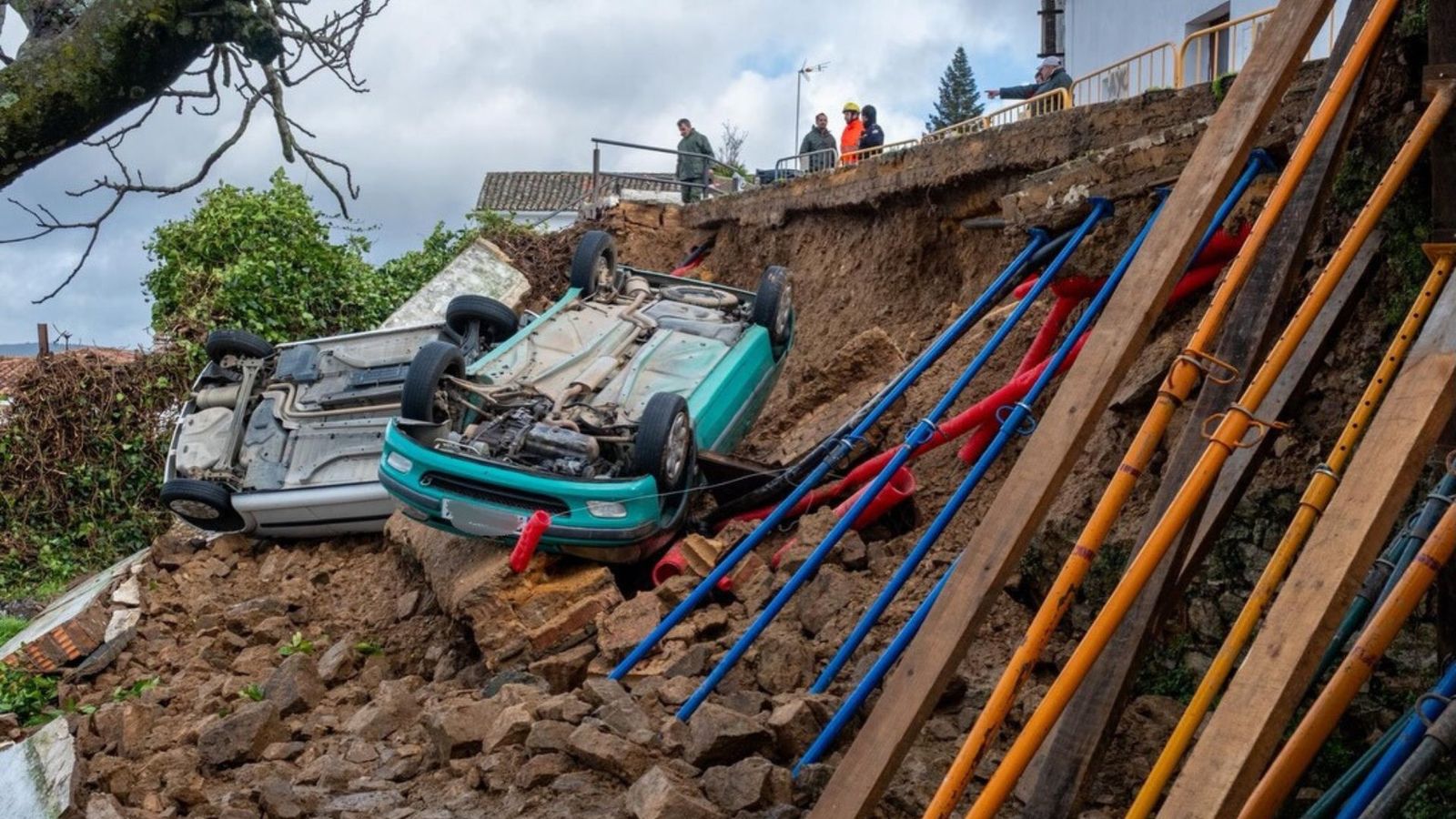 Los dos vehículso que han caído por el terreno tras derribarse el muro de contención en Cortegana.