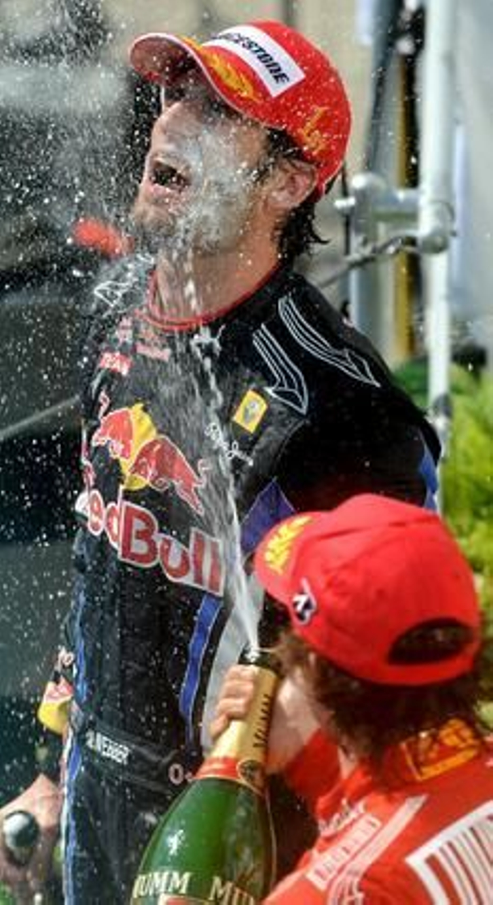 Alonso baña en champagne a Webber. / EFE