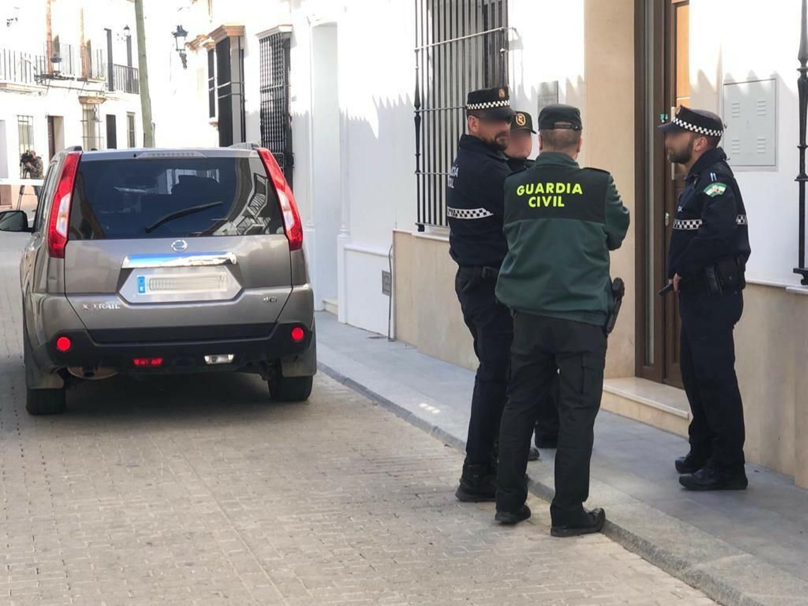Agentes de la Policía Local y de la Guardia Civil, custodiando la vivienda de la calle Delgado Hernández de Bollullos esta mañana.