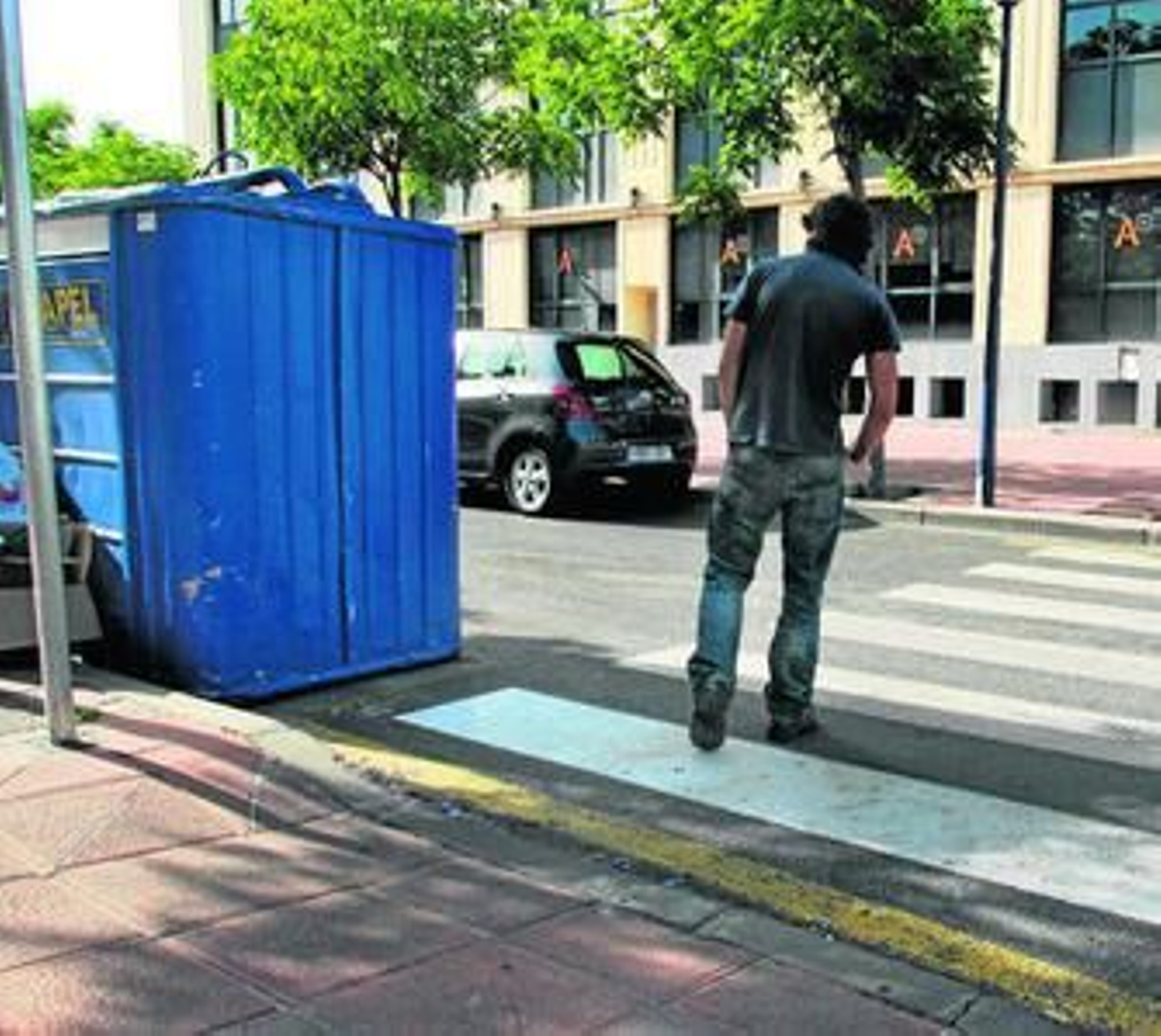 Un contenedor colocado junto a un paso de cebra que impide la visión a los peatones.