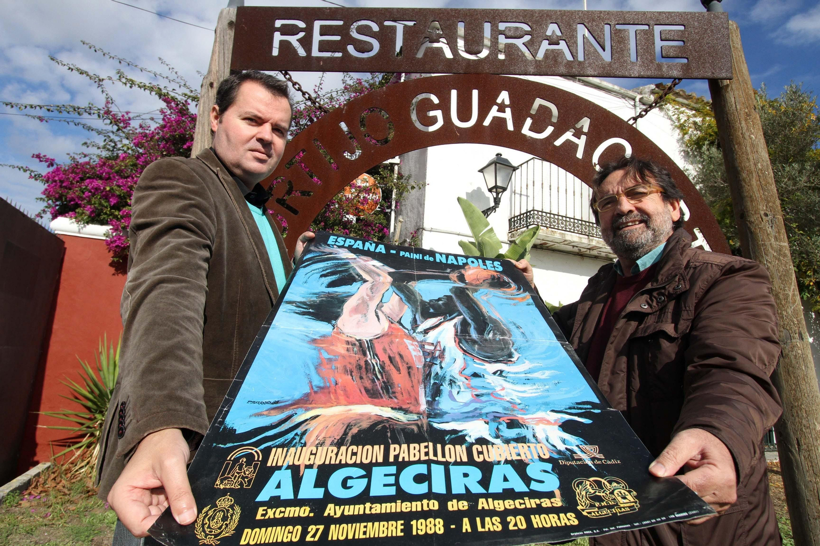 González y Barroso, con el cartel inaugural del pabellón de Algeciras, obra de éste.