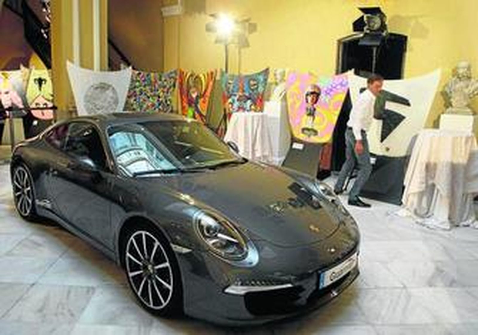 Un modelo de Porsche, junto a algunas obras de la colección, el viernes, en el Palacio Trinidad Grund.