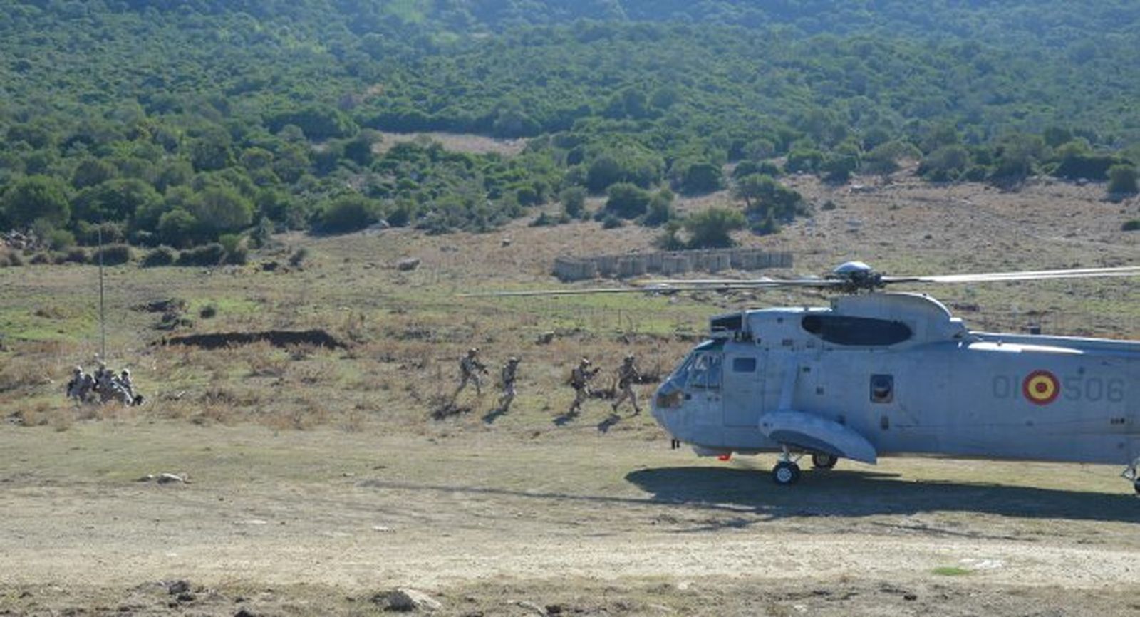 Extracción del equipo de la Fuerza Naval de Guerra Especial tras incursionar contra un objetivo. Un grupo evacua a un herido al helicóptero, mientras sus compañeros agachados les cubren.
