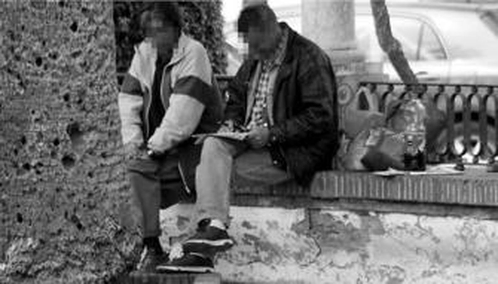 Dos indigentes sentados en la plaza de Las Angustias.