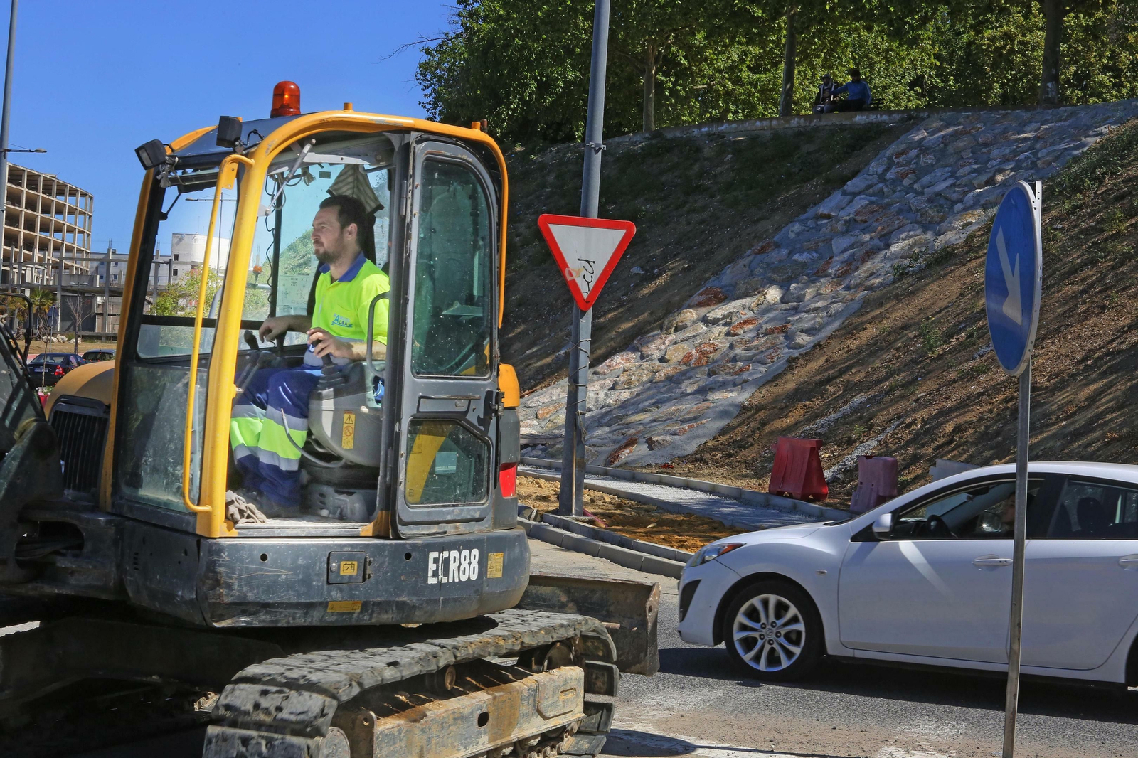 Un trabajador maneja una grúa en las obras que se ejecutan en una carretera de la ciudad.