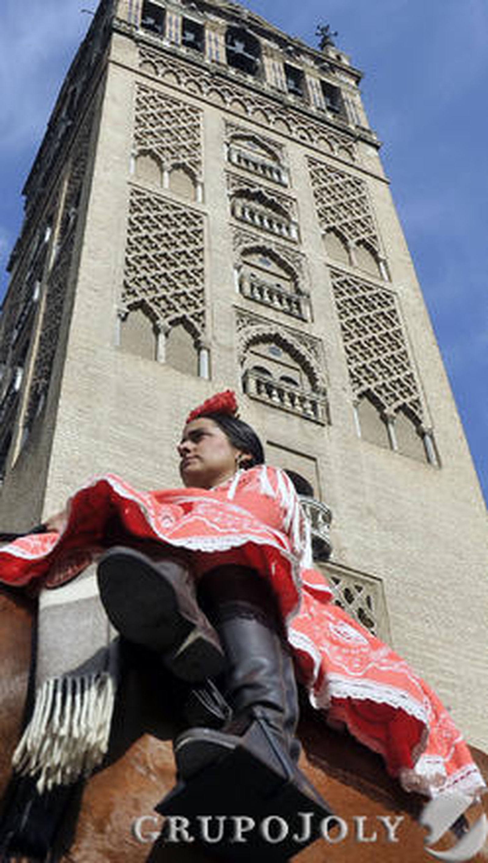 Una jinete, ataviada con traje y calzado de romera, pasa junto a la Giralda.

Foto: Juan Carlos Vázquez