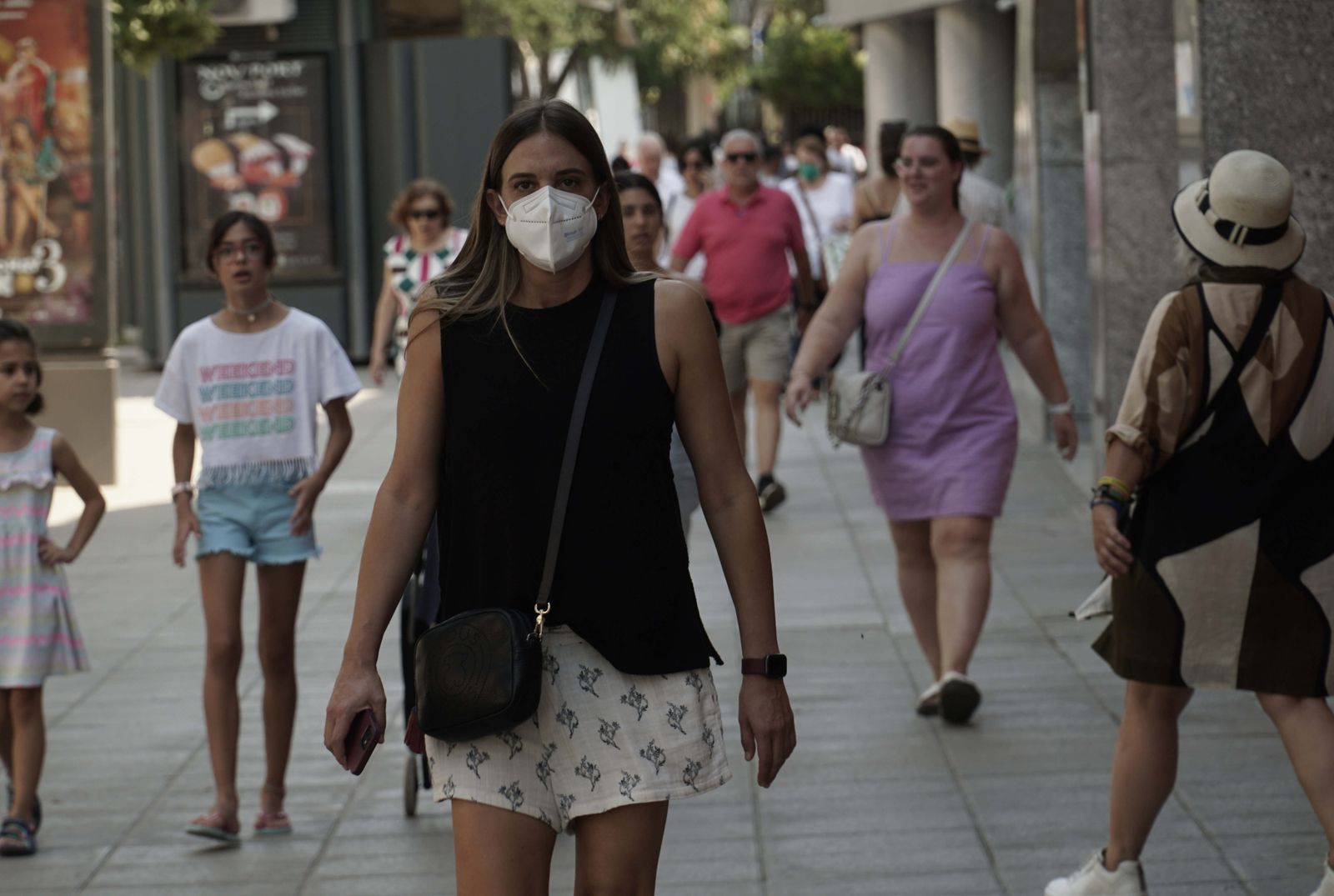 Una joven, con mascarilla por las calles del centro.