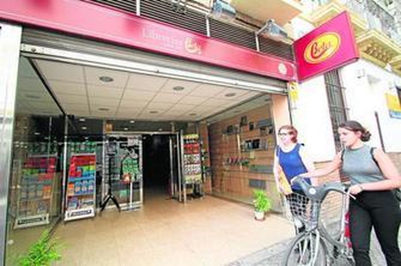 Dos mujeres pasan ante la librería Beta San Pablo, con el escaparate en proceso de desmontaje.