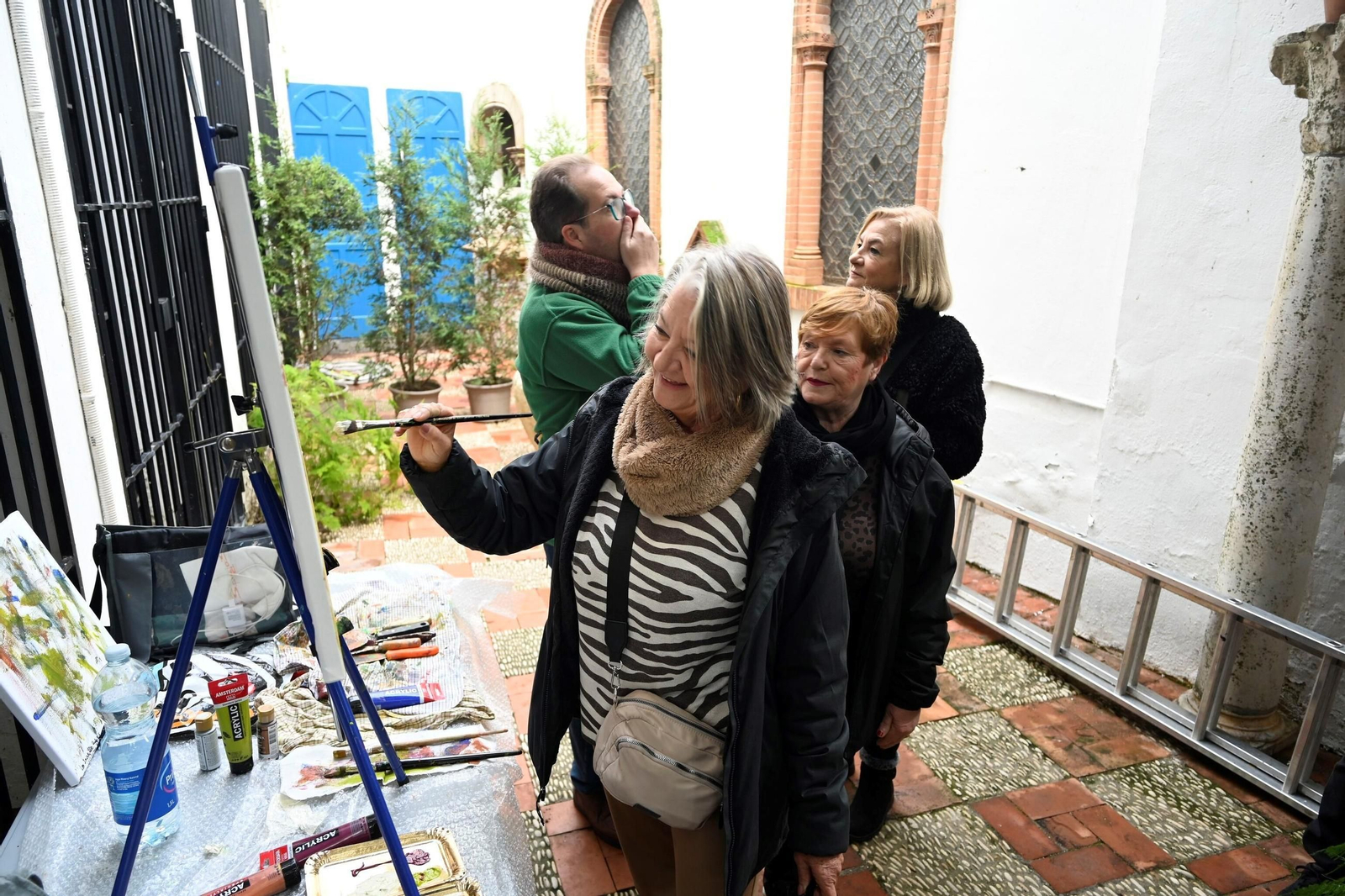 Varias personas participan en la actividad de pintura de la casa patio de Julio Romero de Torres en Córdoba.