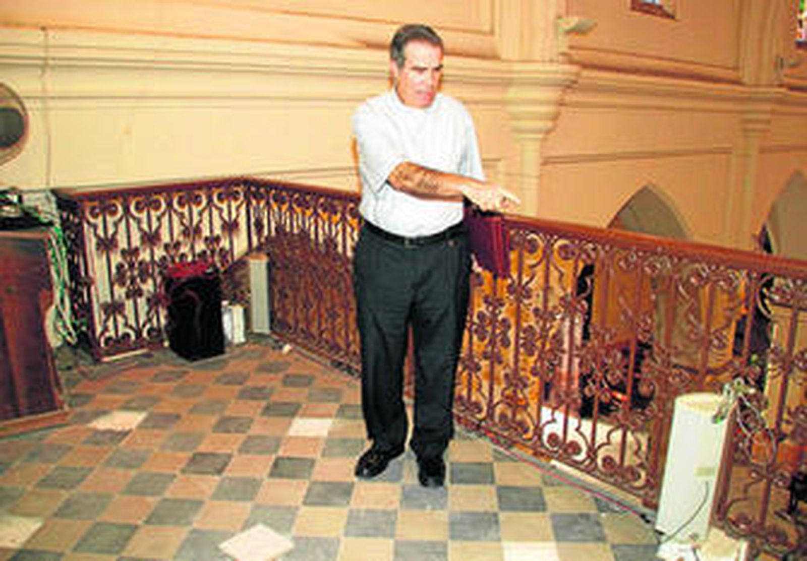 El párroco, Feliciano Fernández, en el coro de la iglesia de Santo Domingo señala la losa donde apareció la carta que indicaba un 'tesoro'.