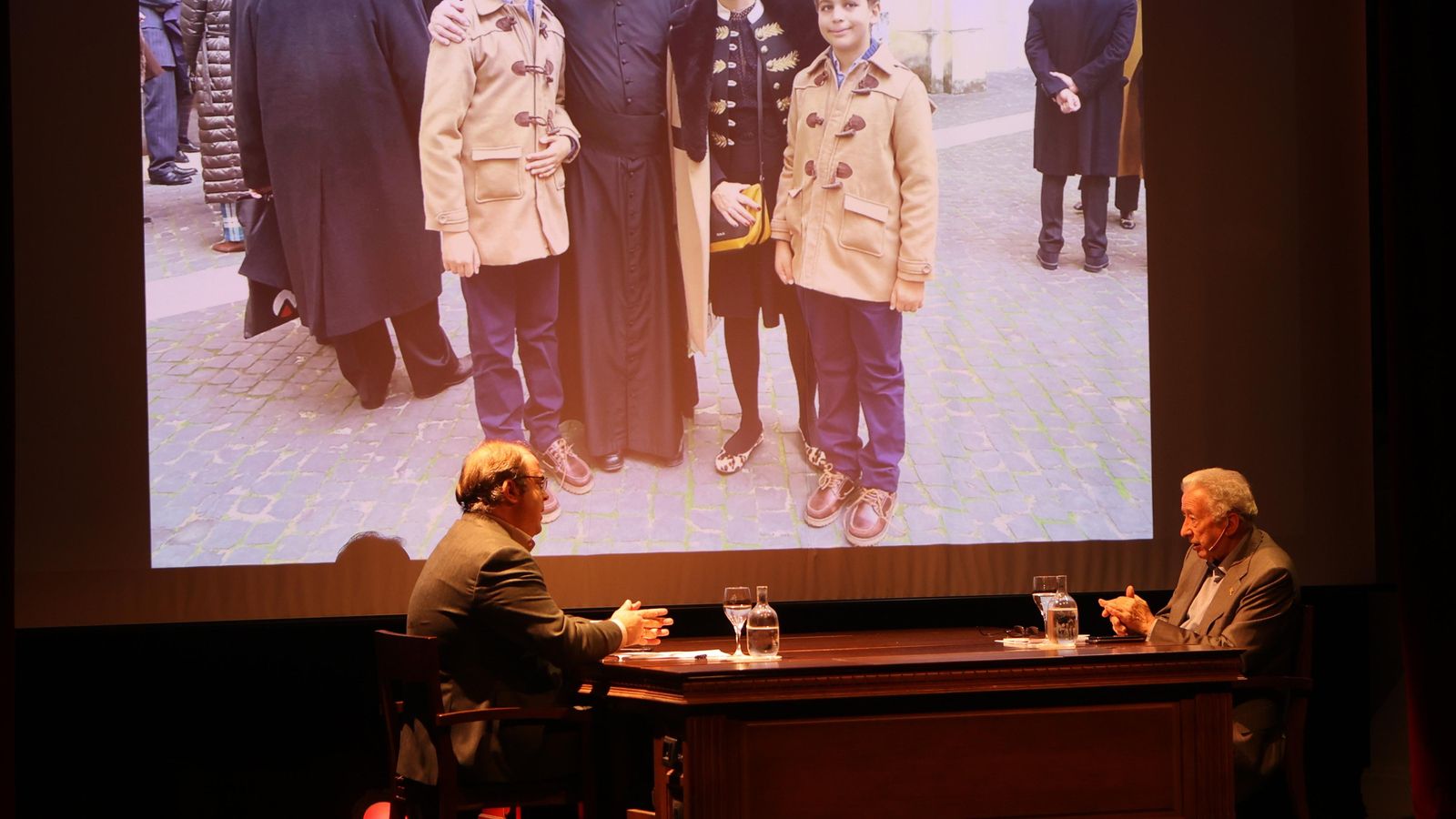 Un momento de la tertulia con una fotografía de fondo de Antonio Pelayo con Amalia Cardenete y Miguel y Manuel Navarro Cardenete en el Palacio de España de Roma.