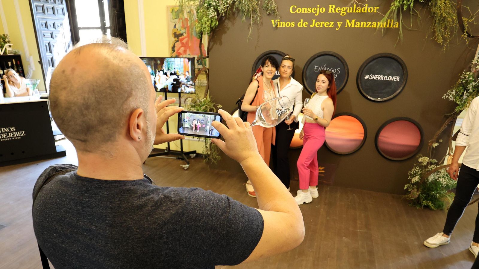 Mujeres posan para una fotografía en el stand del Consejo Regulador de los vinos de Jerez y la Manzanilla de Sanlúcar..