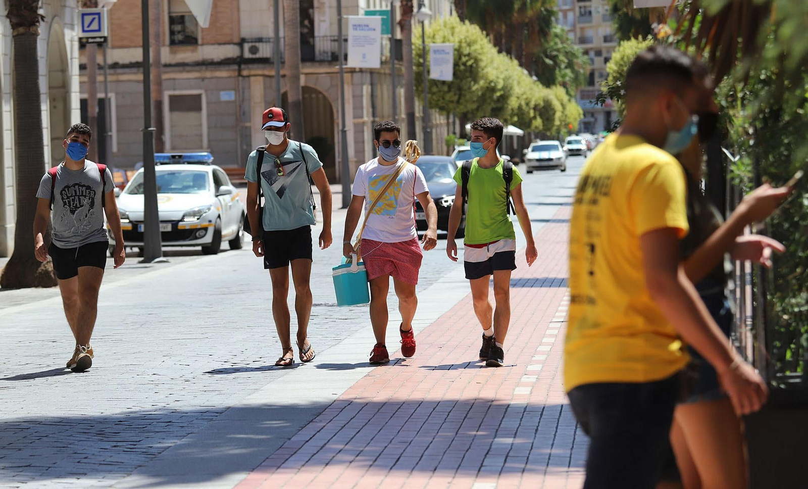 Varios jóvenes con mascarillas por la Gran Vía onubense.