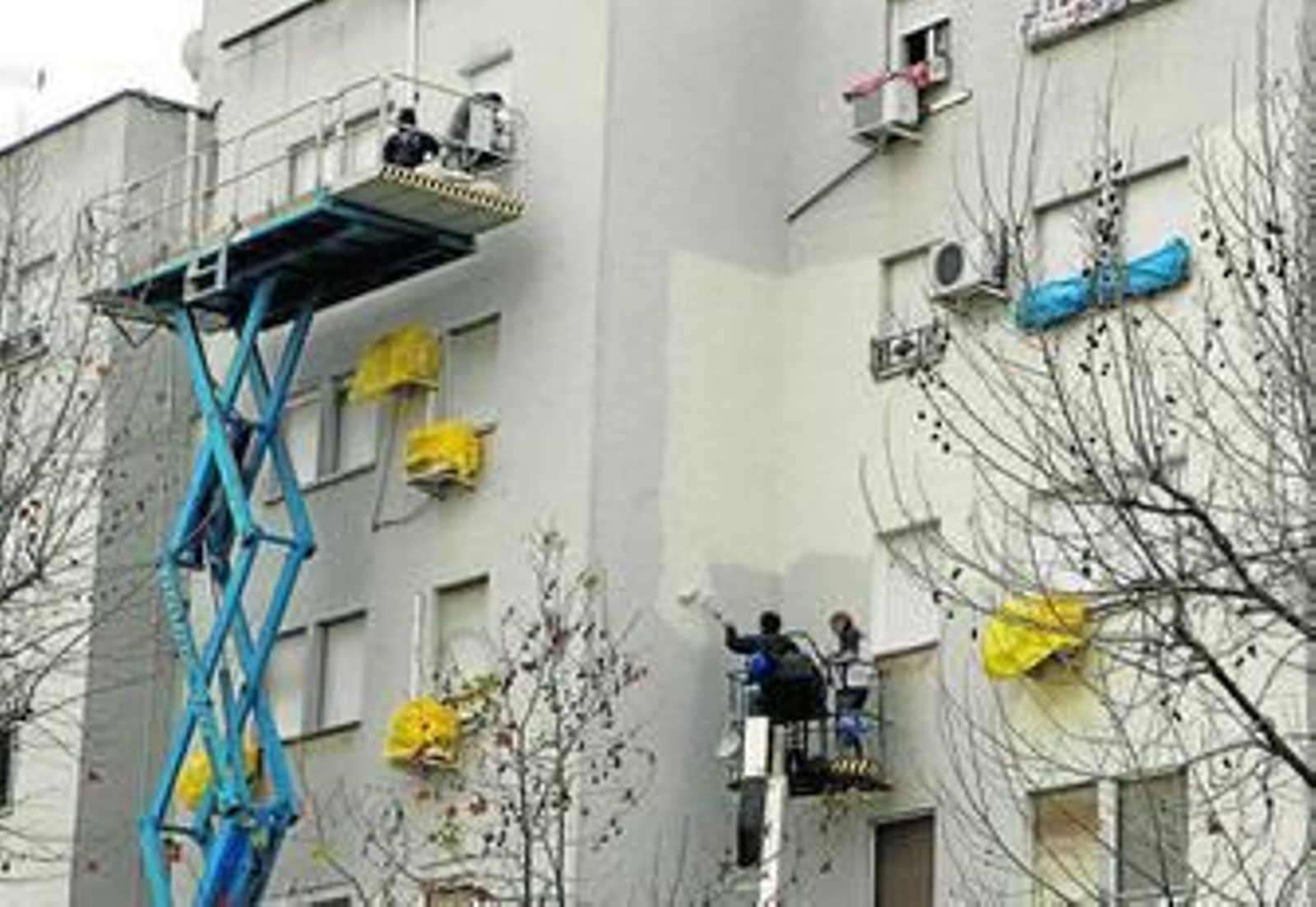 Operarios pintando la fachada de uno de los bloques de viviendas de Príncipe Felipe.