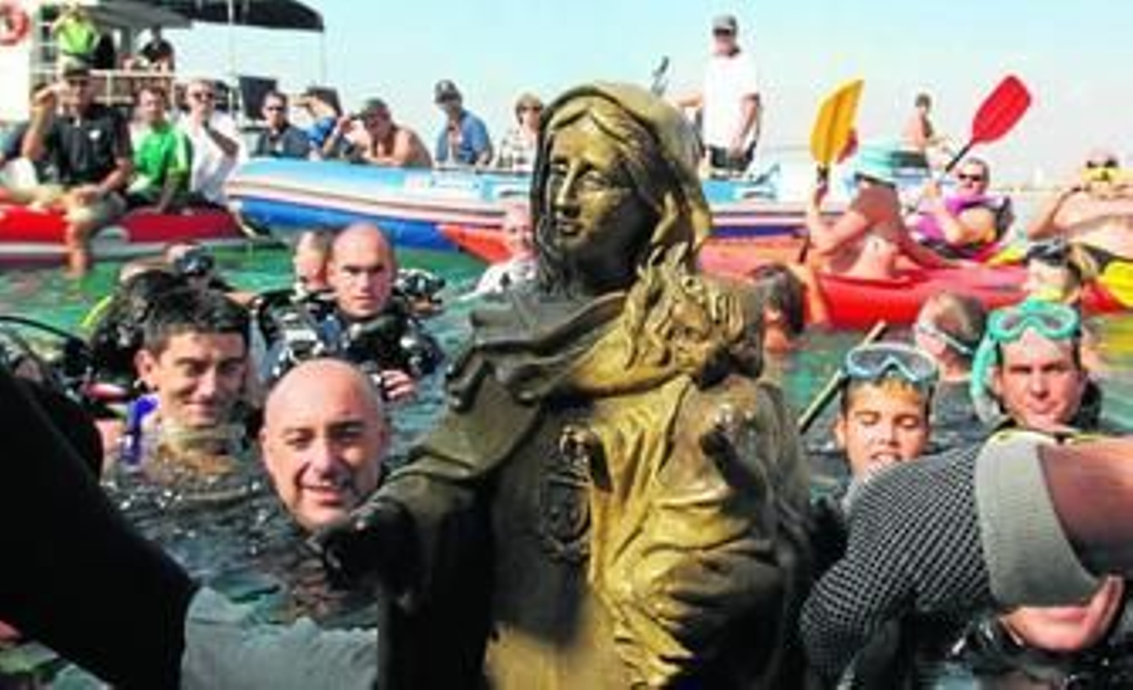 Los submarinistas, ayer, subiendo al barco la Virgen del Carmen en la playa de La Caleta.