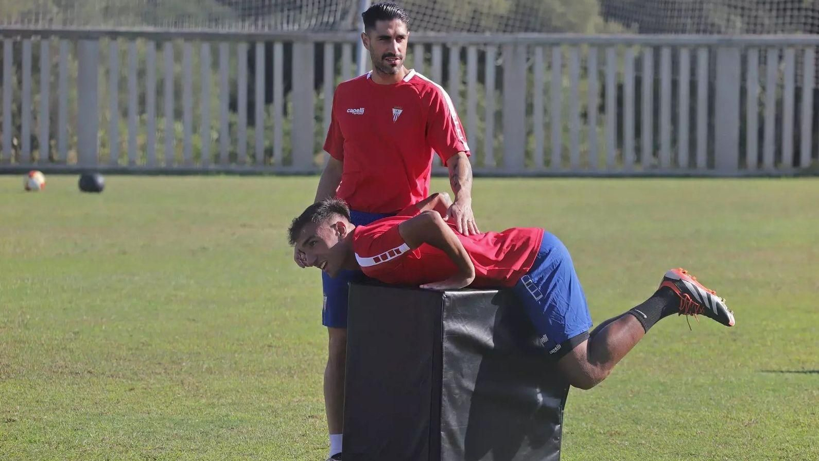 Victor Ruiz, junto a Óscar Castro, que estira sobre un cajón.