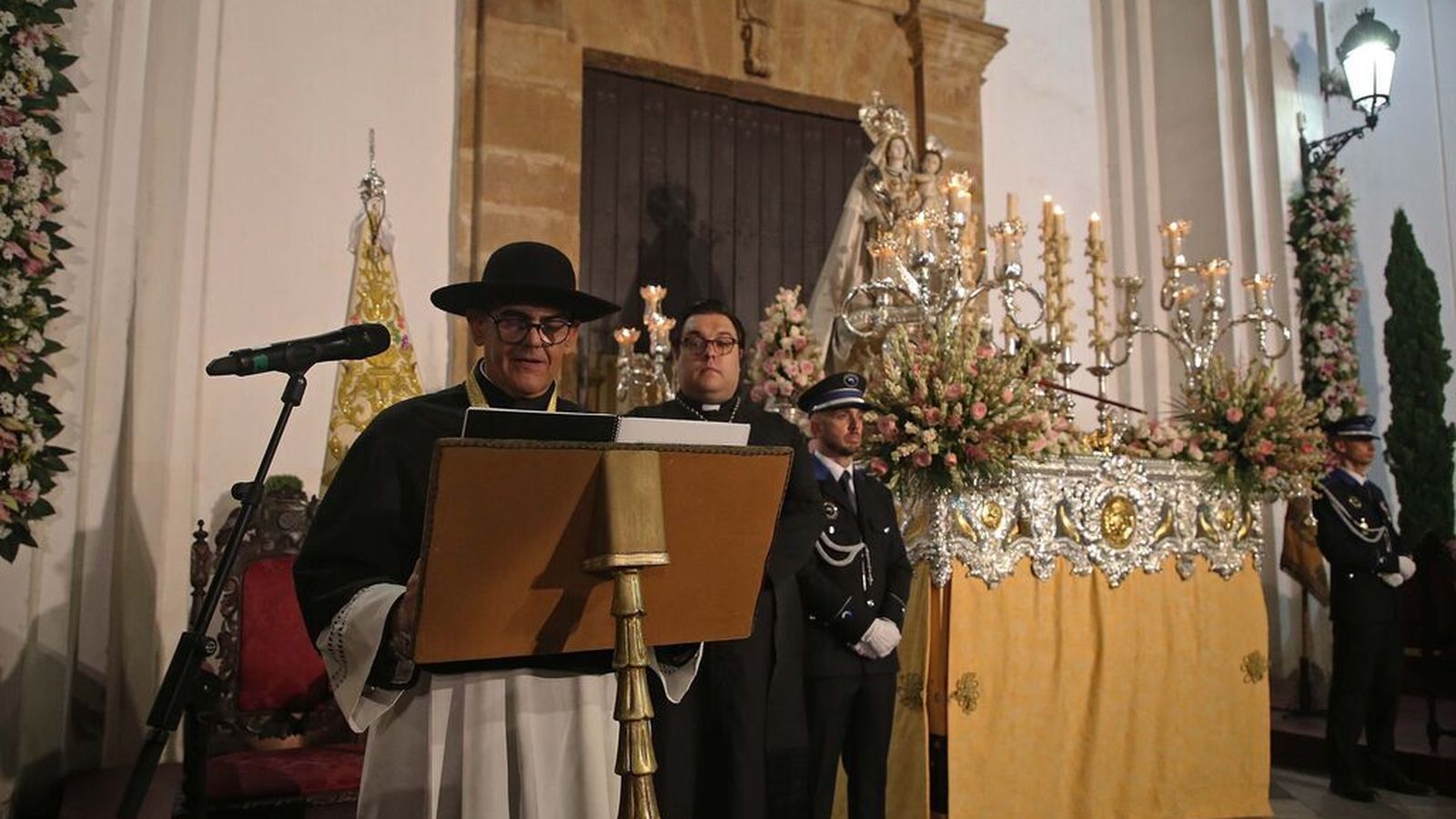 El párroco Juan José Marina bajo el paso de la Virgen de la Palma.