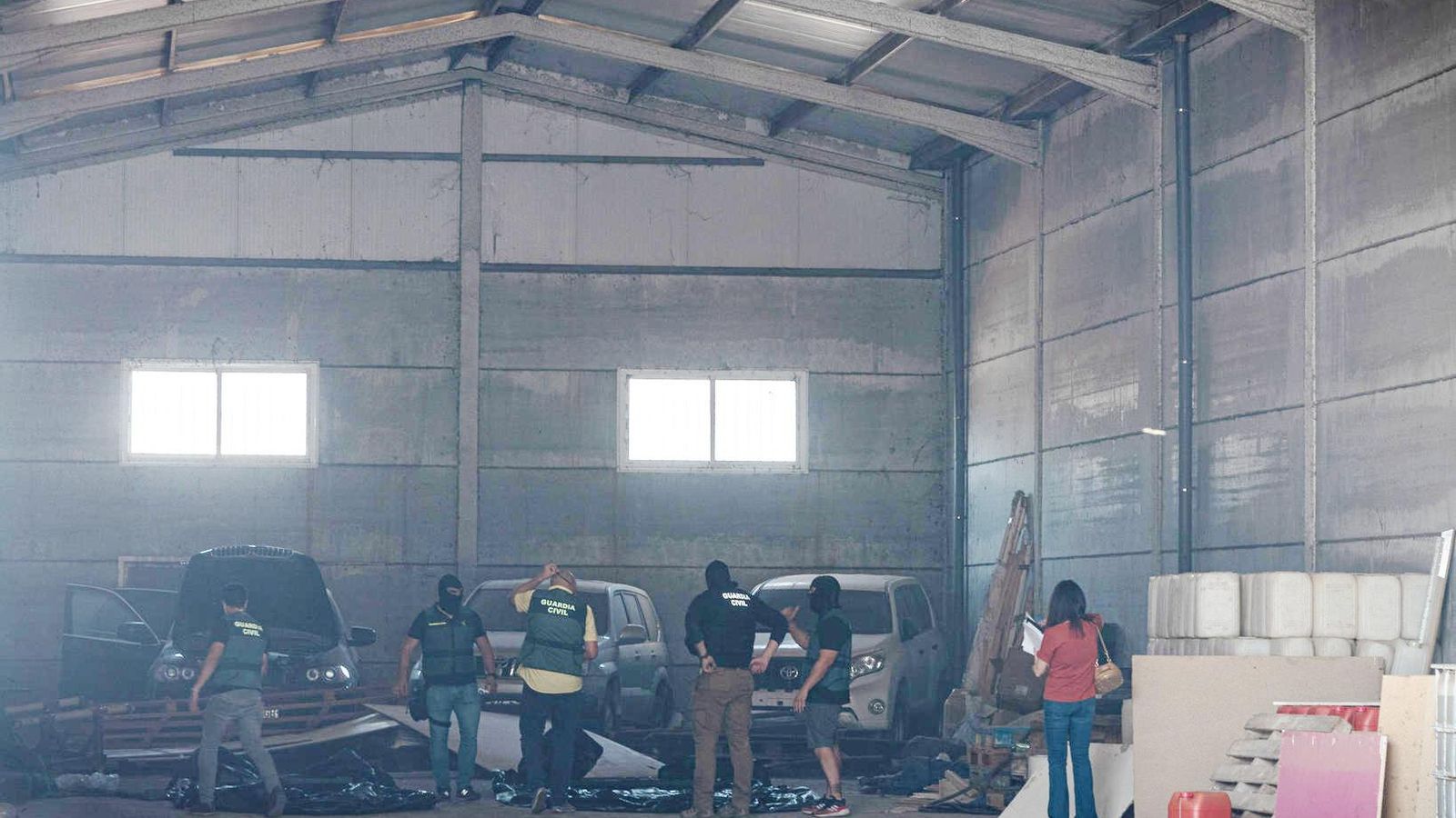 La Guardia Civil interviene en una nave del polígono Indutec de Huelva, con tres coches robados al fondo.