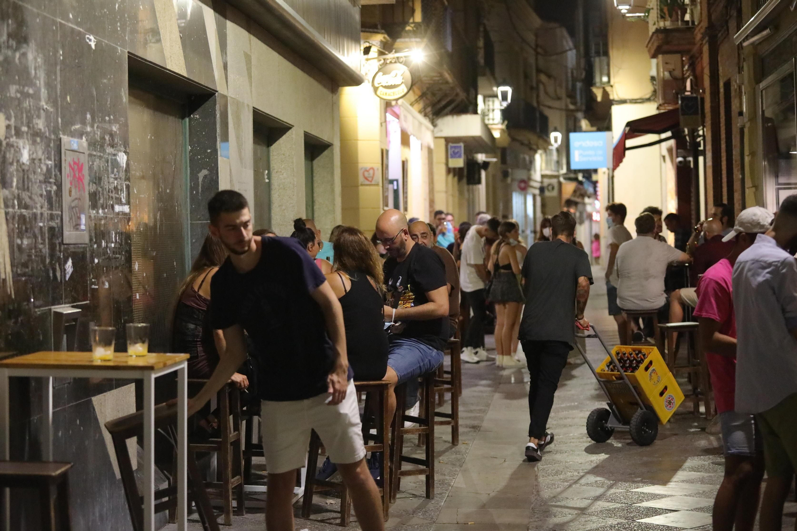 Un trabajador se dispone a dejar un pedido en un bar del centro con buena afluencia en la terraza.