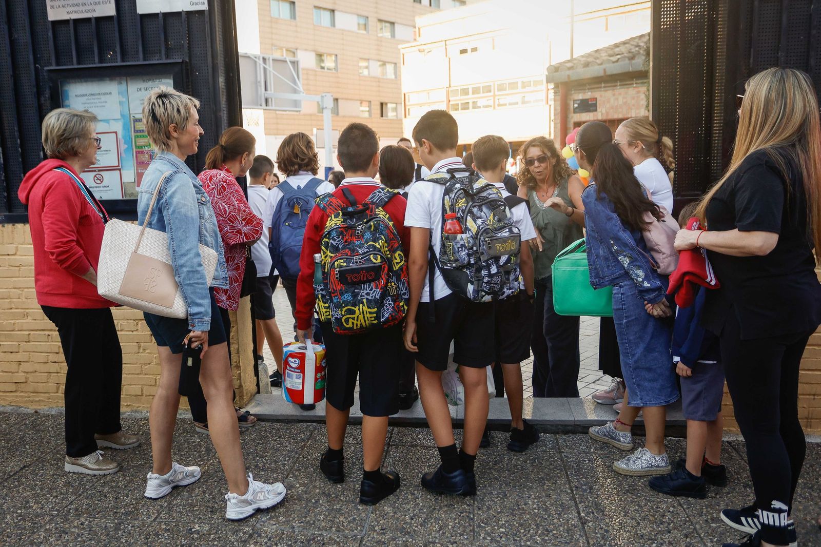 Alumnos entran en un colegio.
