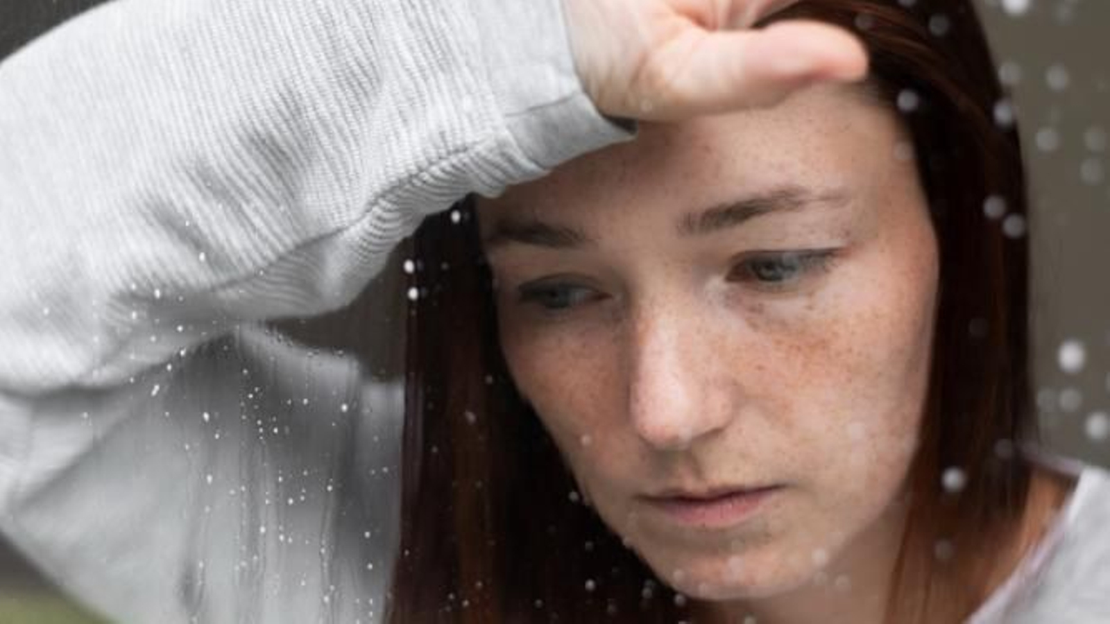 Mujer mirando a través de una ventana.