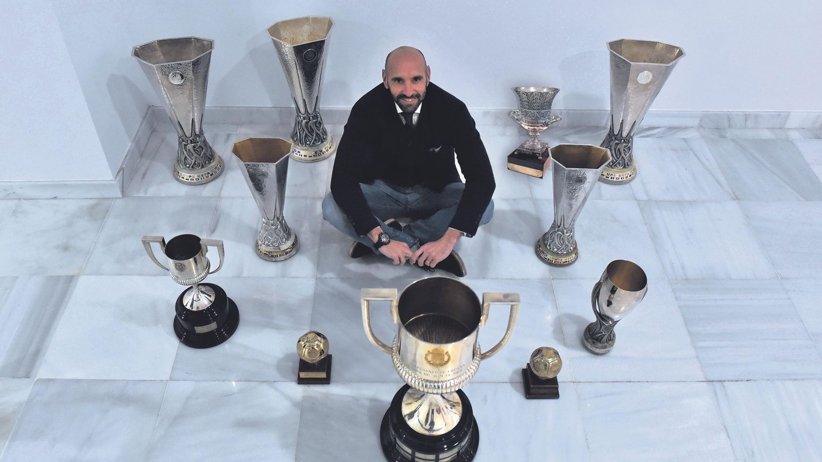 Monchi posa con los nueve títulos y los dos trofeos de mejor equipo del mundo.