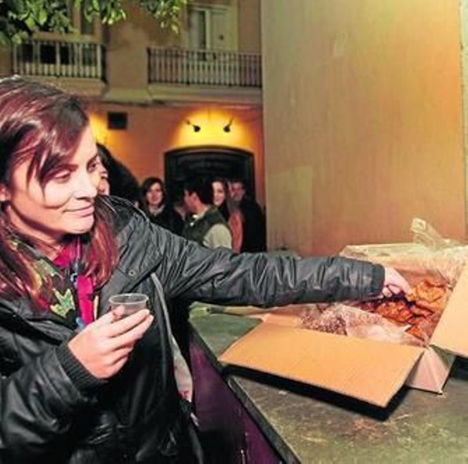 Una asistente a la fiesta de este año se dispone a degustar un pestiño.