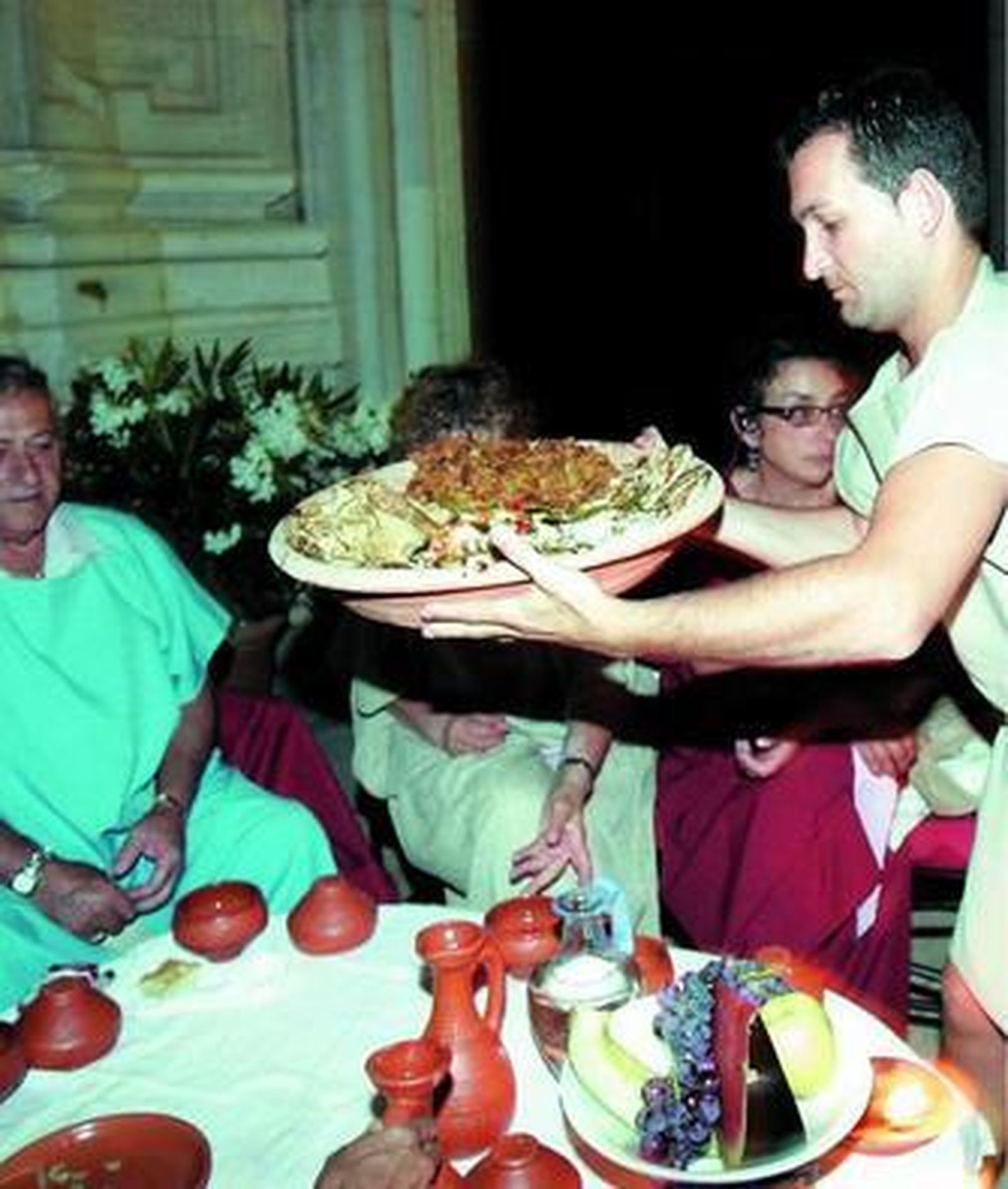 Momento en el que se sirve uno de los platos de las cenas romanas.