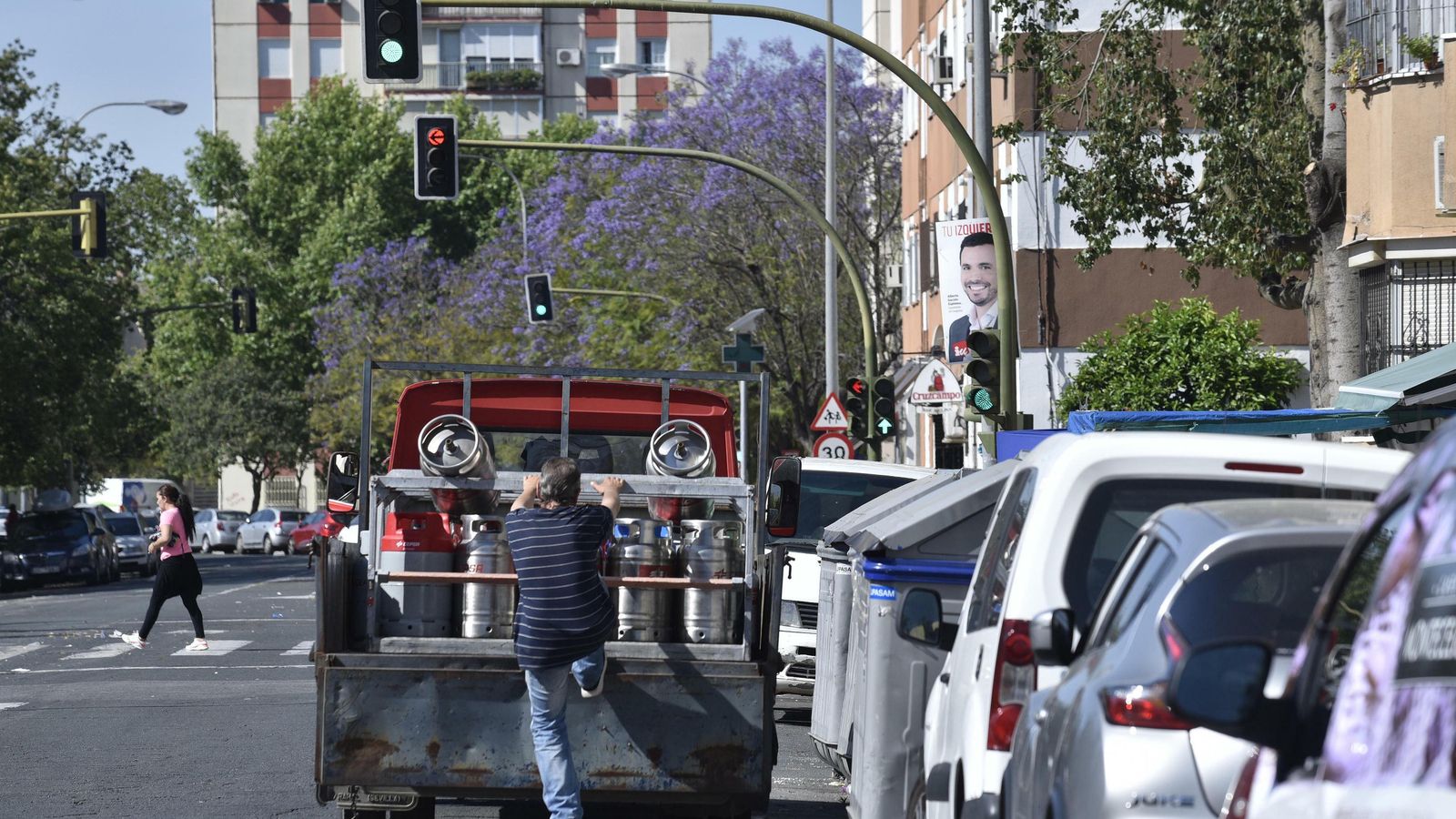 Un repartidor de butano se sube a un vehículo estacionado en doble fila.