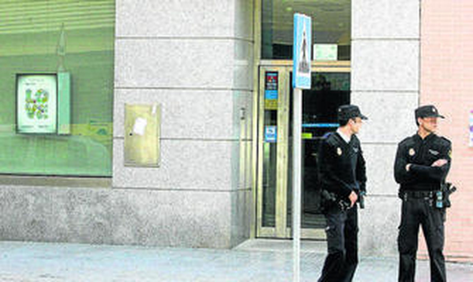 Policías,  junto a la entidad asaltada, poco después de cometerse el atraco,  el pasado 15 de noviembre.