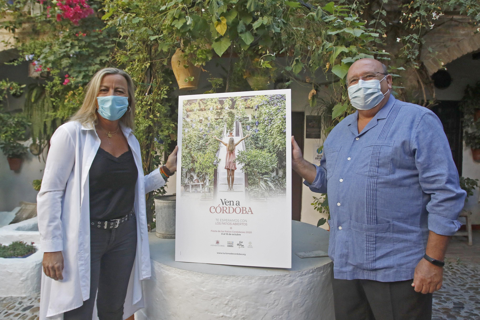 Albás y Roldán posan con el cartel de la campaña de promoción turística.