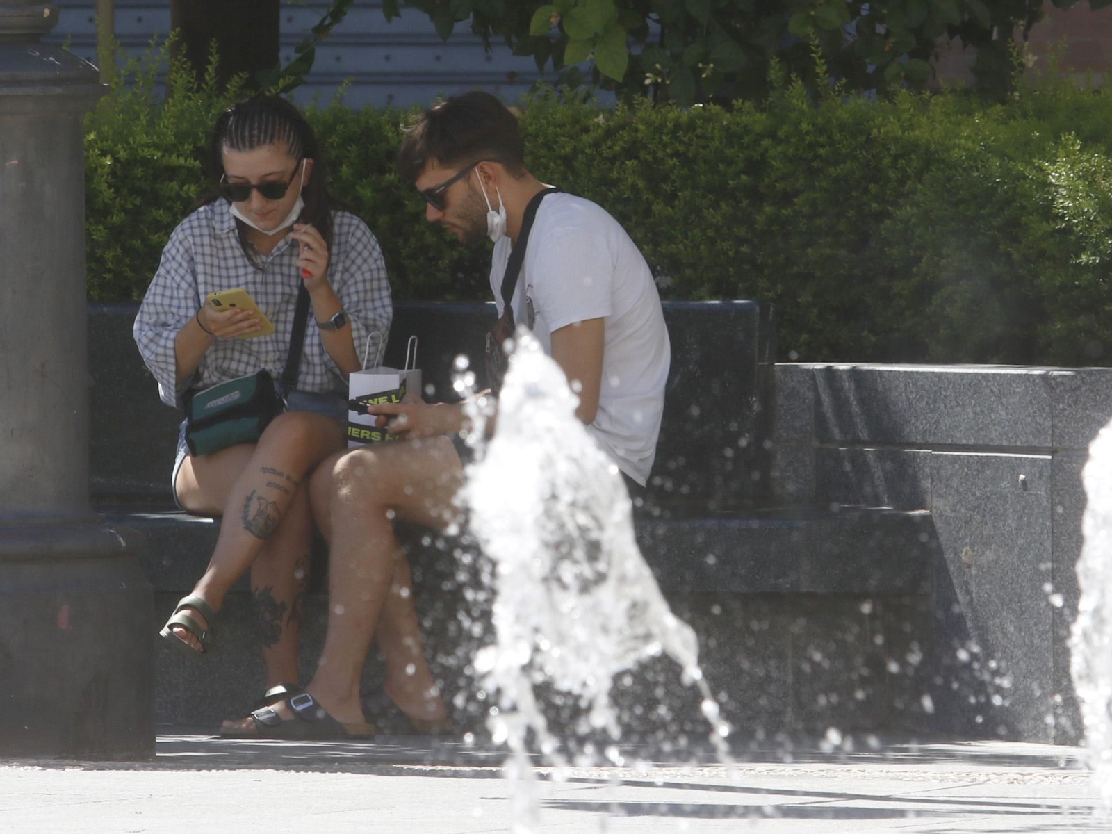 Dos jóvenes se relajan en la plaza de las Tendillas.